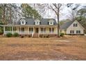 An inviting home with a large porch and a detached garage creating a welcoming atmosphere at 9030 Ethel Rd, North Charleston, SC 29406