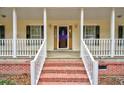 Inviting front porch with brick stairs and white railings provides a cozy entryway at 9030 Ethel Rd, North Charleston, SC 29406