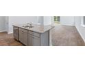 Modern kitchen island with stainless steel dishwasher and sink overlooking the dining and living areas at 1044 Forrest Creek Dr, Summerville, SC 29483