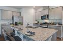 Kitchen island featuring granite countertops, a stainless steel sink, and seating for three at 1066 Forrest Creek Dr, Summerville, SC 29483