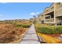 Attractive condos with balconies and a charming boardwalk winding through manicured greenery at 1340 Pelican Watch Villas, Seabrook Island, SC 29455