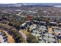Overhead view of condos near tennis courts, roads, and waterways surrounded by lush trees and greenery at 1614 Live Oak Park, Seabrook Island, SC 29455