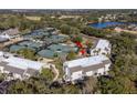 An aerial shot showcasing condos near well-maintained tennis courts, green spaces, and a serene lake at 1614 Live Oak Park, Seabrook Island, SC 29455