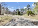 Rear view of a single-story home with a spacious yard surrounded by mature trees at 162 Wal Flo Ln, Moncks Corner, SC 29461