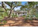 Rear exterior view of house with deck and mature landscaping including palm trees at 2837 Baywood Dr, Seabrook Island, SC 29455
