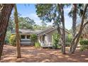 Charming home exterior showcasing a wooden deck with rocking chairs, surrounded by trees at 2837 Baywood Dr, Seabrook Island, SC 29455