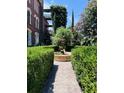Beautiful landscaped garden featuring a fountain surrounded by trimmed hedges and a brick path at 309 Meeting St # 19, Charleston, SC 29401