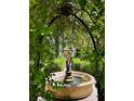 The brick-lined garden features a water fountain and manicured landscaping, viewed through an overhead arbor at 309 Meeting St # 19, Charleston, SC 29401