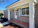 Inviting brick home featuring a covered front porch with stately white columns at 377 Furman Ln, Ladson, SC 29456
