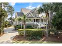Charming two-story home with covered porch, set amongst mature palms and other trees at 4 Falcon Point Rd, Kiawah Island, SC 29455