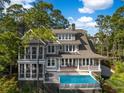 A beautiful home featuring a serene pool with waterfall and a covered porch at 4 Falcon Point Rd, Kiawah Island, SC 29455