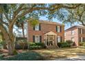 Beautiful two-story brick home with mature trees, tidy landscaping, and classic architectural details at 51 Gadsden St # B, Charleston, SC 29401