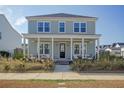 Inviting two-story home featuring a spacious front porch with seating and lush landscaping at 643 Blueway Ave, Summerville, SC 29486