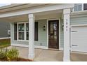 Inviting front porch with painted columns, number display, and a dark wood door at 747 Maynard Ln, Summerville, SC 29486