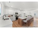 Well-lit kitchen features stainless appliances, white cabinets, a large island with barstool seating, and hardwood floors at 1022 Drakeford St # 10P, Saint George, SC 29477