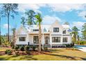 Beautiful home with a metal roof, well-maintained landscaping, and a palm tree in the front yard at 105 Peninsula Dr, Ravenel, SC 29470