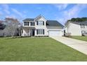 Beautiful two-story home featuring vinyl siding, a manicured lawn, and a long driveway leading to the garage at 107 Hainsworth Dr, North Charleston, SC 29418