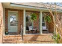 Inviting front porch featuring brick detail, seating, and hanging plants creating a welcoming entrance at 1228 Penny Cir, Mount Pleasant, SC 29464