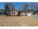 Inviting brick home with black shutters, a well-maintained lawn, and a one-car garage, creating a cozy curb appeal at 1258 Redeemer Dr, Hanahan, SC 29410