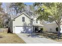 Two-story home featuring a front-facing garage, a manicured lawn, and a cozy front porch at 126 Moon Shadow Ln, Summerville, SC 29485
