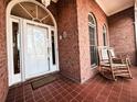 Inviting brick porch features two rocking chairs, tiled flooring, and a charming entryway at 1407 Congressional Blvd, Summerville, SC 29483