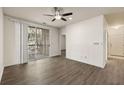 Living room features a ceiling fan, hardwood floors, sliding doors to a balcony, and a white door to the side at 1600 Long Grove Dr # 1313, Mount Pleasant, SC 29466