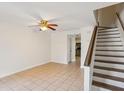 Bright living room featuring neutral tile flooring, staircase, ceiling fan and kitchen access at 1735 Boone Hall Dr # K14, Charleston, SC 29407