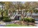 Inviting townhome exteriors featuring elevated entryways and attached garages, nestled among mature trees at 1902 Long Bend Dr # 1B, Seabrook Island, SC 29455