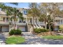 Beautifully designed townhomes with elevated entrances, garages, and tropical landscaping offer curb appeal at 1902 Long Bend Dr # 1B, Seabrook Island, SC 29455
