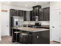 Modern kitchen featuring black cabinets, stainless steel appliances, granite countertops, and a stylish island at 200 Silver Palm Ln, Summerville, SC 29485