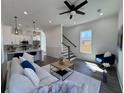 Sunlit living room with ceiling fan, plush seating, and a staircase, creating a cozy and inviting atmosphere at 2012 Forest Ave, North Charleston, SC 29405