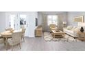 Bright living room with luxury vinyl floors and modern furniture, including a sofa and armchair at 203 West Bradford Pointe Dr, Summerville, SC 29483