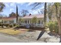 Charming white home with red roof, brick walkway and front porch at 214 E Doty Ave, Summerville, SC 29483
