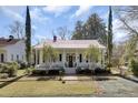 Charming white home with red roof, brick walkway and front porch at 214 E Doty Ave, Summerville, SC 29483