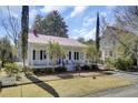 Charming white home with red roof, brick walkway and front porch at 214 E Doty Ave, Summerville, SC 29483