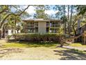 Charming condo building with multiple levels, surrounded by lush trees and manicured shrubbery at 214 Sea Cloud Cir, Edisto Island, SC 29438
