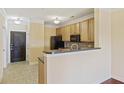 Kitchen featuring wood cabinets, black appliances, and a breakfast bar with tile flooring at 2244 Ashley Crossing Dr # 1236, Charleston, SC 29414