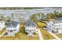 Aerial view of marsh community with white homes and lush landscaping, showing its proximity to marsh and water views at 3554 Clambank Dr, Mount Pleasant, SC 29466