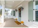 Charming front porch features neutral siding, sage shutters, seasonal decor, and a wood floor at 3554 Clambank Dr, Mount Pleasant, SC 29466