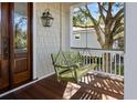 Comfortable green wooden swing hanging from a porch with wood flooring and white railings and trim at 4008 Cameron Blvd, Isle of Palms, SC 29451