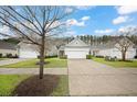Picture of well-manicured lawn and driveways of three houses with light-colored exteriors and two-car garages at 523 Eastern Isle Ave, Summerville, SC 29486