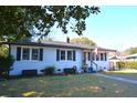 Charming white brick home with black shutters, an American flag, and well-manicured lawn at 5273 Potomac St, North Charleston, SC 29405