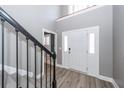 Bright foyer with soaring ceilings, wood-look flooring, and staircase with black metal railings at 8745 Alexandria Dr, North Charleston, SC 29420