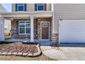Inviting front porch featuring stone detailing, a decorative front door, and tidy landscaping at 105 Endicott Ct, Summerville, SC 29486