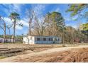 Charming single-story home with gray siding, complemented by a large yard and a backdrop of mature trees at 116 Wisteria Falls Trl, Saint Stephen, SC 29479