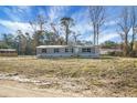 Inviting single-story home with gray siding and black shutters, surrounded by a spacious yard ready for landscaping at 116 Wisteria Falls Trl, Saint Stephen, SC 29479