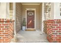 Inviting front porch with brick accents and a decorative wreath on the front door at 1204 Dingle Rd, Mount Pleasant, SC 29466