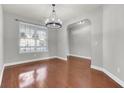 Bright dining room with hardwood floors, elegant chandelier, and a large window at 138 Back Tee Cir, Summerville, SC 29485
