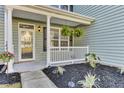 Inviting front porch with lush landscaping and a decorative white railing at 138 Back Tee Cir, Summerville, SC 29485