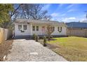 Charming single-story home with brick driveway and manicured lawn; inviting front porch with pink door at 1605 Evergreen St, Charleston, SC 29407